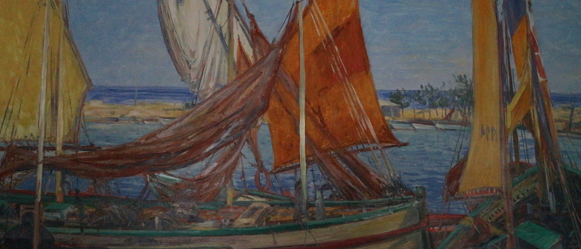 Das Foto zeigt den Ausschnitt eines Acrylbildes mit mehreren bunten Segelbooten im Vordergrund in mediterraner Küstenlandschaft.