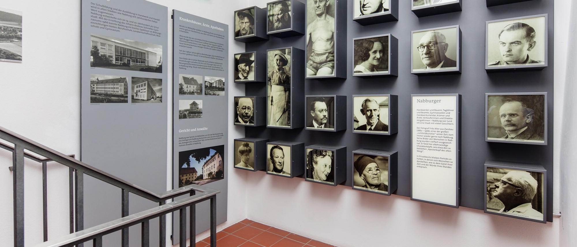 Das Foto zeigt den Blick in die stadtgeschichtliche Dauerausstellung. Leuchtkästen mit Fotos von bekannten und unbekannten Nabburgern.