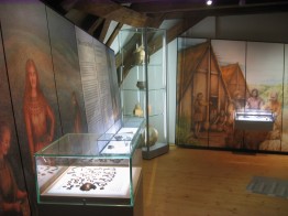 Das Foto zeigt den Blick in die archäologische Dauerausstellung mit Lebensbildern der Bronzezeit und Jungsteinzeit sowie Vitrinen mit entsprechenden Exponaten.